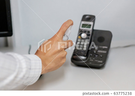 Man hand spraying alcohol sanitizer bottle to the 63775238