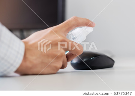 Man hand spraying alcohol sanitizer bottle to the Man hand spraying alcohol sanitizer bottle to the 63775347