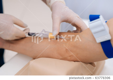 Close-up of the process of taking blood from the vein from man. Close-up of the process of taking blood from the vein from man. 63778306