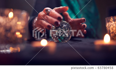 Fortuneteller woman's hands with predictions ball 63780458