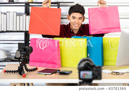 Young Asian male online merchant blogger using 63781369