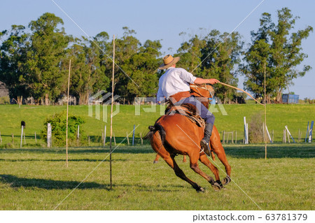 Gaucho rides a horse race on a track at a Criolla Festival in Uruguay, South America, also been seen in Argentina Gaucho rides a horse race on a track at a Criolla Festival in Uruguay, South America, also been seen in Argentina 63781379