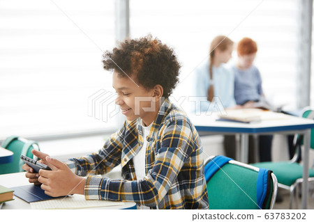 Smiling African Boy Playing Online Games in Class 63783202
