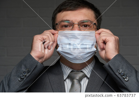 a man puts a mask on his face for antivirus a man puts a mask on his face for antivirus 63783737