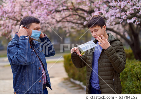 father and son with a face mask are in the city 63784152