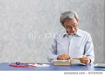 Asian Japen elder doctor reading a book at clinic 63784508