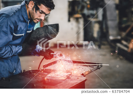 industry worker tig welding steel with safety mask for protect eyesight in metal factory. industry worker tig welding steel with safety mask for protect eyesight in metal factory. 63784704