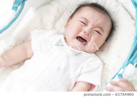 7 month old girl lying on bouncer 63784960