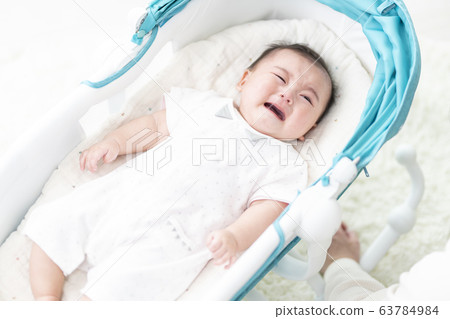 7 month old girl lying on bouncer 63784984