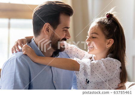 Affectionate young daddy embracing little kid daughter. 63785461