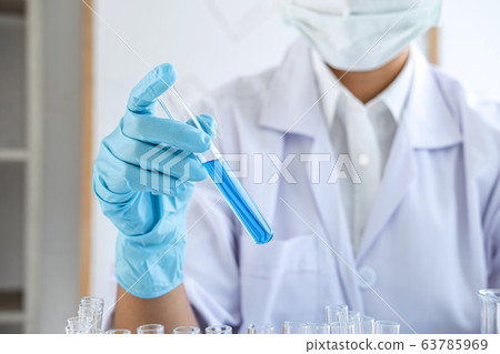 Scientist or medical in lab coat holding test tube 63785969