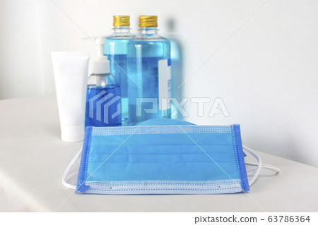 Medical mask and alcohol sanitizer for cleaner sterilize on white table. Medical mask and alcohol sanitizer for cleaner sterilize on white table. 63786364