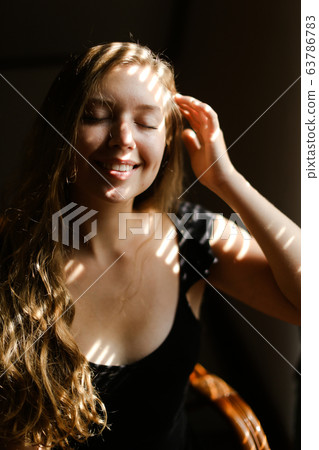 Close up portrait of young smiling woman with striped shadows. Close up portrait of young smiling woman with striped shadows. 63786783