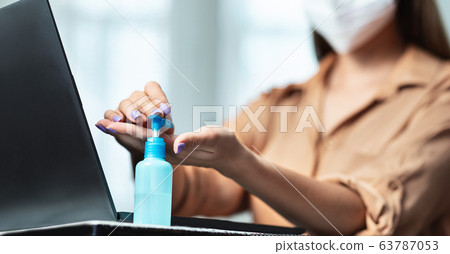 Unrecognizable woman wearing mask and using sanitizer gel Unrecognizable woman wearing mask and using sanitizer gel 63787053