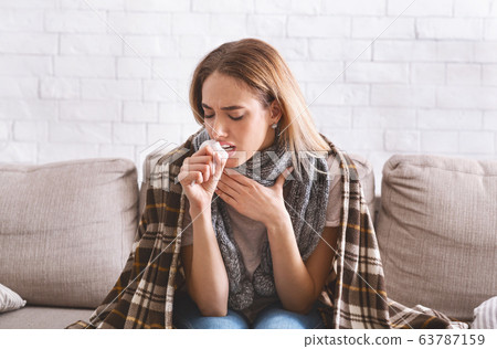 Woman with scarf in throat and plaid on shoulders 63787159