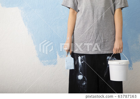 Woman with roller and bucket standing on wall background Woman with roller and bucket standing on wall background 63787163