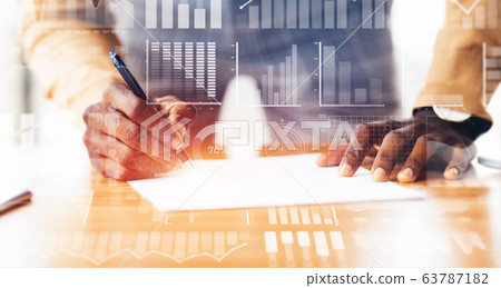 African American employee doing paperwork at desk. Collage with double exposure of business data on transparent screen African American employee doing paperwork at desk. Collage with double exposure of business data on transparent screen 63787182