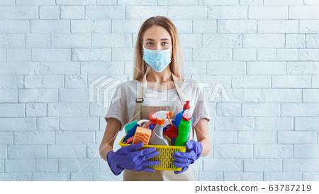 Girl in protective mask with cleaning supplies 63787219