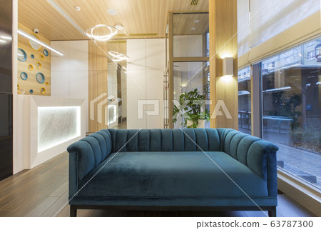 Big blue soft sofa in waiting area of children dentistry 63787300