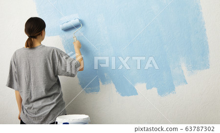 Woman paint wall at home, free space 63787302