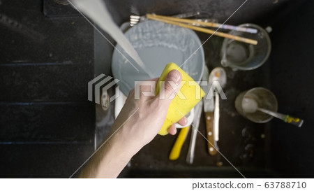 Washing dirty dishware in black sink 63788710