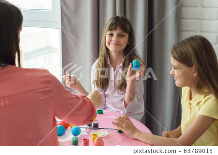 Happy girl shows a painted easter egg 63789015