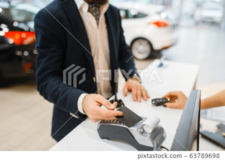 Man pays for new auto in car dealership 63789698