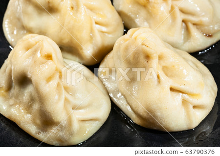 Manti (oiled with butter close up on black plate 63790376