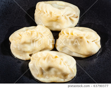 few of boiled Manti on black plate 63790377