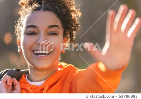 Mixed Race African American Girl Teenager With Perfect Teeth Smiling and Waving 63790992