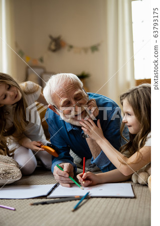 Twin girls having fun with mirthful grandfather stock photo 63793175