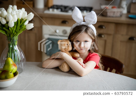 Lovely girl with her toy in the kitchen stock photo Lovely girl with her toy in the kitchen stock photo 63793572
