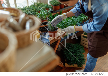 Girl in work gloves loosening the soil 63794220