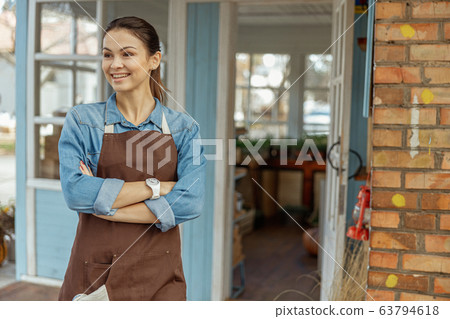 Smiling girl in work clothes staring at something 63794618