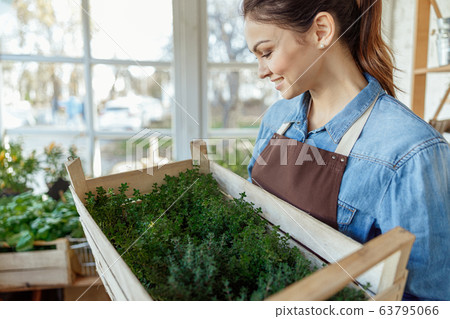 Beautiful dark-haired woman rejoicing at her harvest 63795066