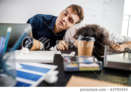 Two tired workers sitting at the table Two tired workers sitting at the table 63795945