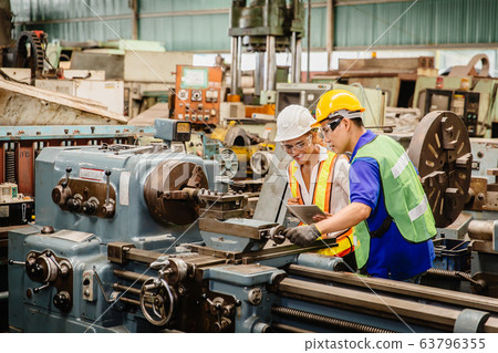 Mix race gender women worker working together help each other to work in heavy industry machine Mix race gender women worker working together help each other to work in heavy industry machine 63796355
