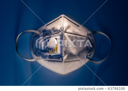 N95 mask on white table with dramatic contrast blue lighting 63798100