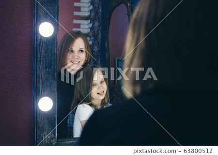 fashionable stylish portrait of woman and girl. the models looking in the mirror. girl in reflection. concept work, modeling fashionable stylish portrait of woman and girl. the models looking in the mirror. girl in reflection. concept work, modeling 63800512
