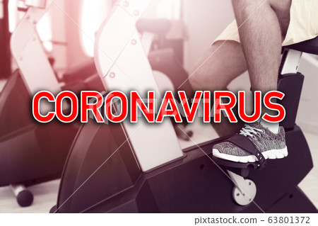 Sign Coronavirus over man doing sports at gym 63801372