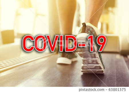 Sign COVID-19 over man doing sports at gym Sign COVID-19 over man doing sports at gym 63801375