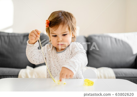 Small toddler girl playing slime at home. Activity for child at home 63802620