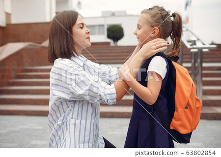 Mother prepare little daughter to school 63802854