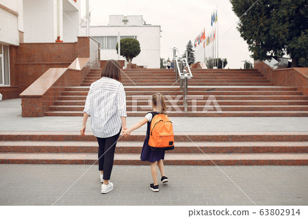 Mother prepare little daughter to school 63802914