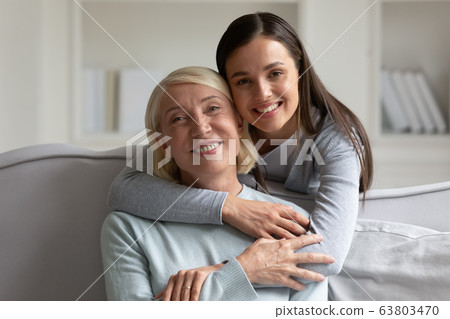 Portrait of happy senior mom and adult daughter hugging 63803470