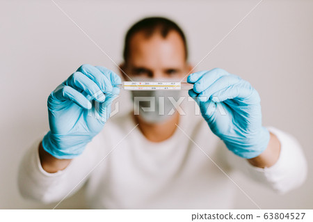 man measuring temperature with thermometer on 63804527