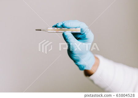 man measuring temperature with thermometer on 63804528