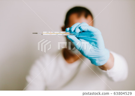 man measuring temperature with thermometer on 63804529