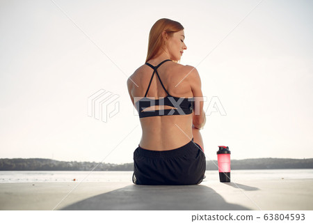 Beautiful woman training by the water 63804593