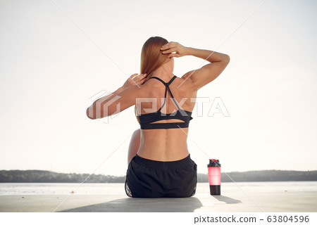 Beautiful woman training by the water Beautiful woman training by the water 63804596